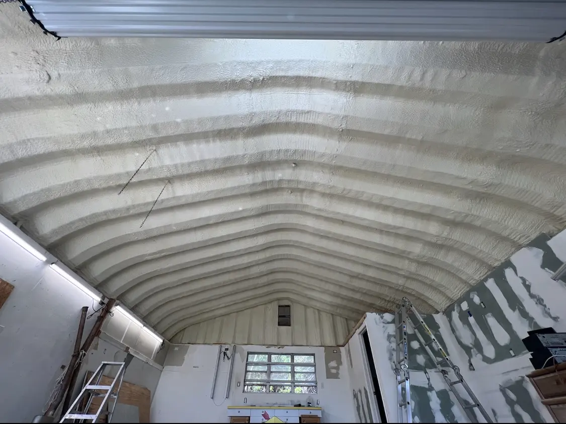 Spray polyurethane foam applied to the underside of a metal roof deck in Rosenberg
